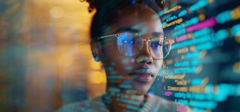 Pictorial representation of vulnerabilities in Vertex AI. A Black woman wearing glasses, looking intently at colorful computer code projected on a screen, highlighting a focus on technology and coding.