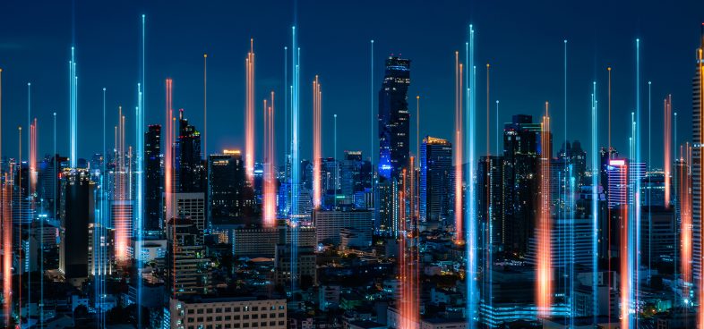 Pictorial representation of CVE-2025-31324. Nighttime cityscape with illuminated skyscrapers and vibrant light trails in the sky.
